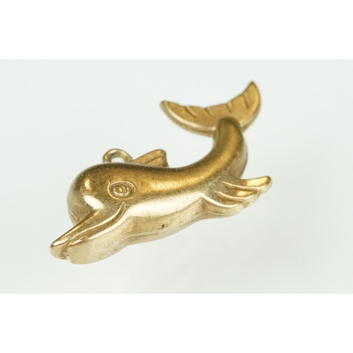 105 - 9ct yellow gold dolphin charm; a yellow metal ladder charm indistinctly stamped 750; and an enamelle... 