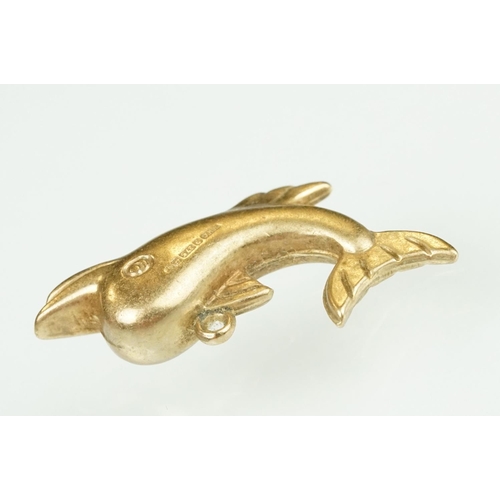 105 - 9ct yellow gold dolphin charm; a yellow metal ladder charm indistinctly stamped 750; and an enamelle... 