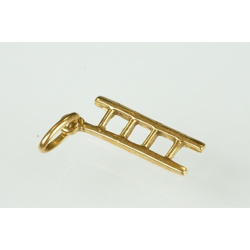 105 - 9ct yellow gold dolphin charm; a yellow metal ladder charm indistinctly stamped 750; and an enamelle... 