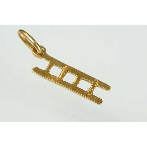 105 - 9ct yellow gold dolphin charm; a yellow metal ladder charm indistinctly stamped 750; and an enamelle... 