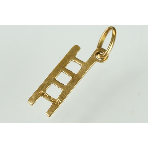 105 - 9ct yellow gold dolphin charm; a yellow metal ladder charm indistinctly stamped 750; and an enamelle... 