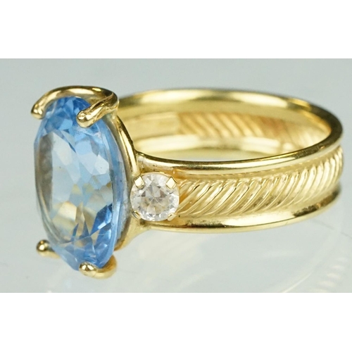 111 - Blue topaz and white stone ring, the band stamped 750, textured band, ring size K½