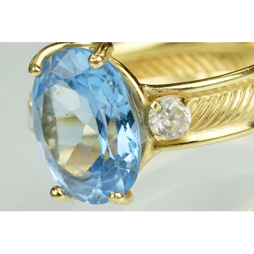 111 - Blue topaz and white stone ring, the band stamped 750, textured band, ring size K½