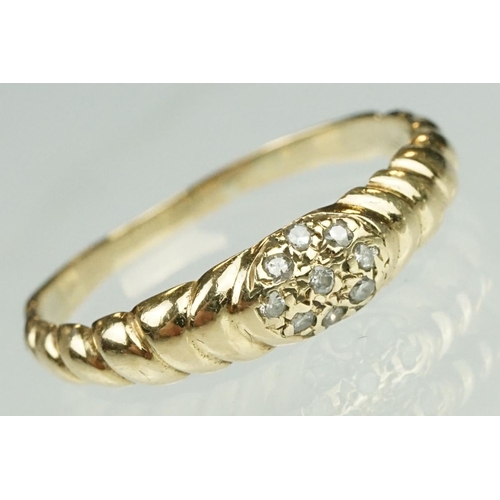 124 - Diamond yellow metal ring, nine small round cut diamonds in flower head design, reeded shoulders, ri... 