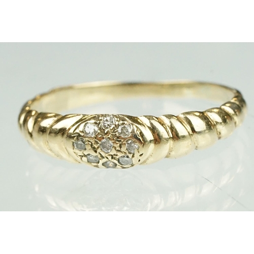 124 - Diamond yellow metal ring, nine small round cut diamonds in flower head design, reeded shoulders, ri... 