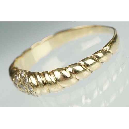 124 - Diamond yellow metal ring, nine small round cut diamonds in flower head design, reeded shoulders, ri... 