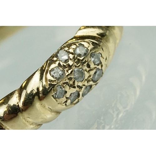 124 - Diamond yellow metal ring, nine small round cut diamonds in flower head design, reeded shoulders, ri... 