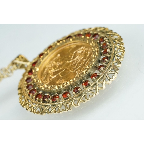 13 - Queen Elizabeth II full sovereign coin pendant necklace, the coin dated 1974, garnet surround, 9ct g... 