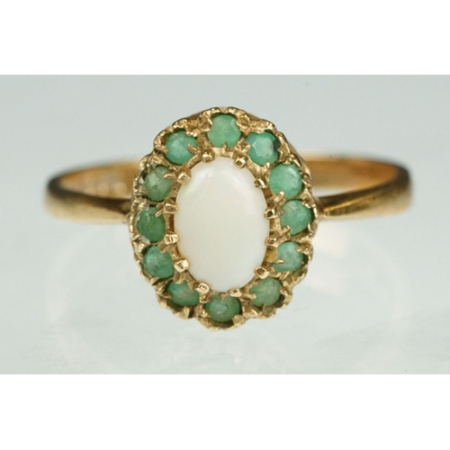 136 - Emerald and opal 9ct yellow gold cluster ring, the oval precious white opal displaying orange and re... 