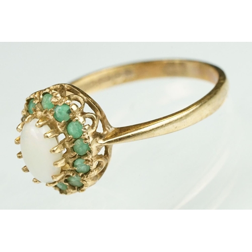 136 - Emerald and opal 9ct yellow gold cluster ring, the oval precious white opal displaying orange and re... 