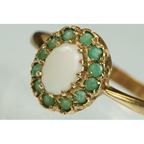 136 - Emerald and opal 9ct yellow gold cluster ring, the oval precious white opal displaying orange and re... 