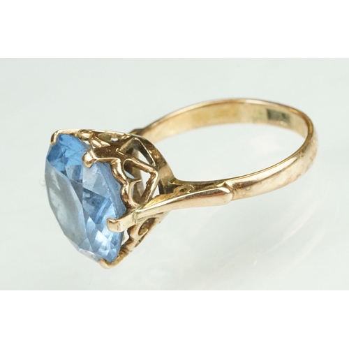 139 - Blue stone rose metal ring, the blue stone possibly paste or synthetic spinel, claw set, ring size O... 