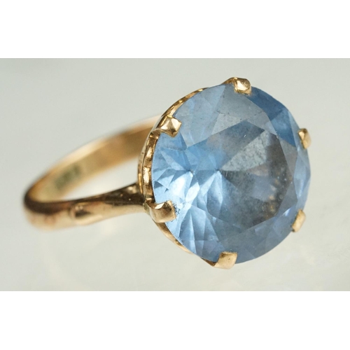 139 - Blue stone rose metal ring, the blue stone possibly paste or synthetic spinel, claw set, ring size O... 