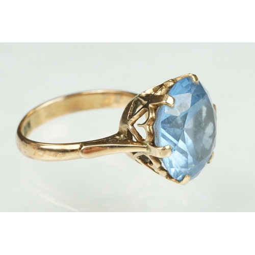 139 - Blue stone rose metal ring, the blue stone possibly paste or synthetic spinel, claw set, ring size O... 