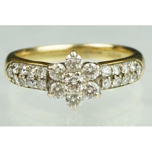 17 - Diamond flower head 18ct yellow gold ring, the centre round brilliant cut diamond weighing approx 0.... 