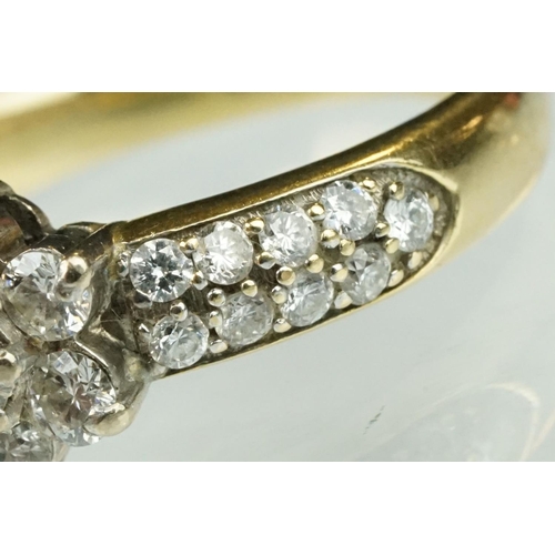 17 - Diamond flower head 18ct yellow gold ring, the centre round brilliant cut diamond weighing approx 0.... 