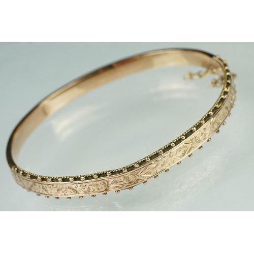 173 - Rose gold hinged bangle, the upper half with floral and foliate scroll decoration, bead detailing, t... 