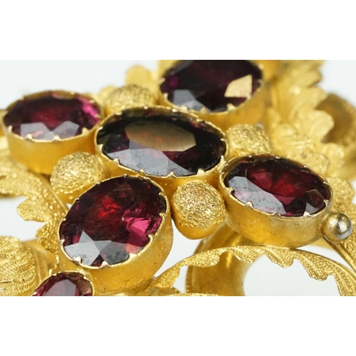 3 - Early Victorian garnet yellow metal brooch, seven graduated oval mixed cut garnets, the largest meas... 