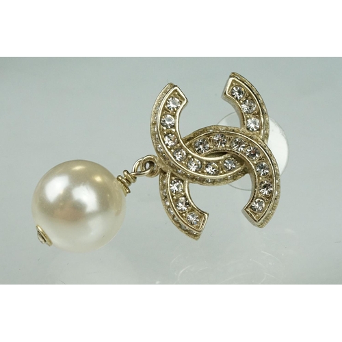 31 - Pair of Chanel costume jewellery earrings having white stone set cross C's to the heads with simulat... 