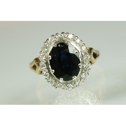 45 - Sapphire and diamond halo dress ring being set with an oval cut blue sapphire with a halo of round c... 