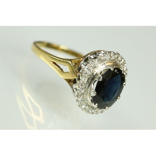 45 - Sapphire and diamond halo dress ring being set with an oval cut blue sapphire with a halo of round c... 