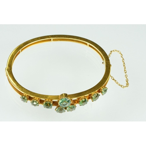 5 - Late 19th century green stone 18ct yellow gold hinged bangle, nine round cut green stones, possibly ... 