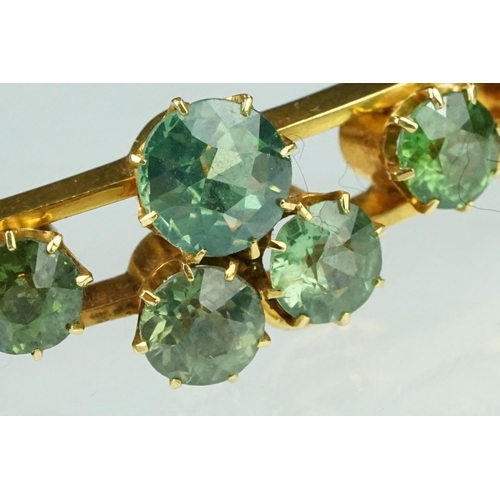 5 - Late 19th century green stone 18ct yellow gold hinged bangle, nine round cut green stones, possibly ... 