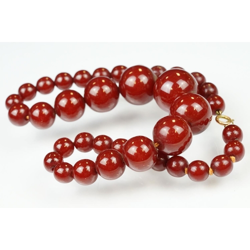 60 - 1930s cherry bakelite beaded necklace having graduating round beads and a spring ring clasp. Measure... 