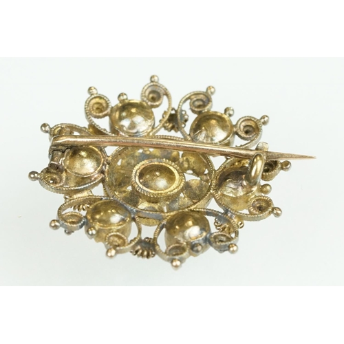 61 - 19th Century yellow metal cannetille brooch of round design set with seven round cut foil back stone... 