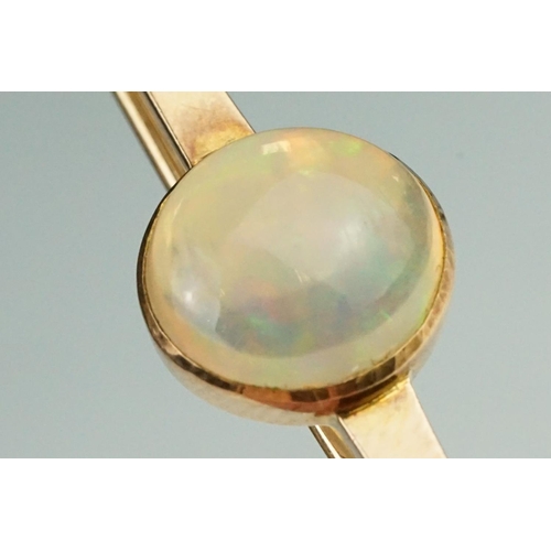 80 - Ethiopian white opal 9ct rose gold bar brooch, the round cabochon cut opal displaying green, yellow,... 