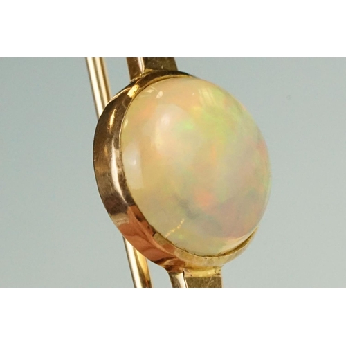 80 - Ethiopian white opal 9ct rose gold bar brooch, the round cabochon cut opal displaying green, yellow,... 