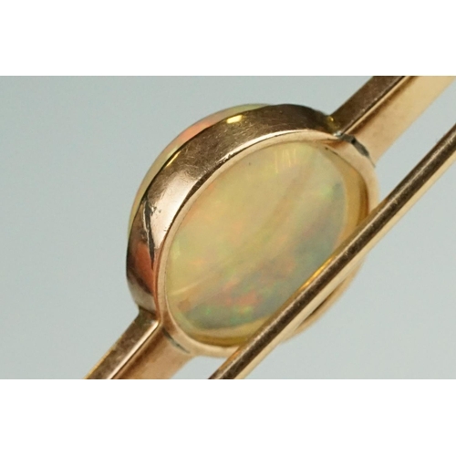 80 - Ethiopian white opal 9ct rose gold bar brooch, the round cabochon cut opal displaying green, yellow,... 