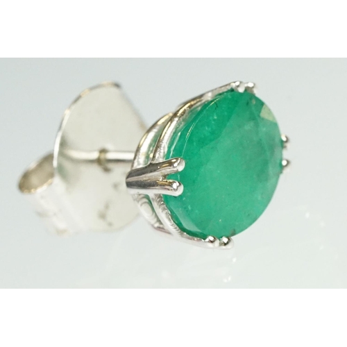 94 - Pair of emerald white metal stud earrings, the oval mixed cut emerald measuring approx 10mm x 8mm, c... 