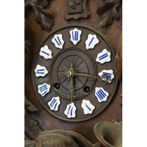 16 - 19th Century carved black forest pendulum wall clock having a round clock to the centre with enamell... 