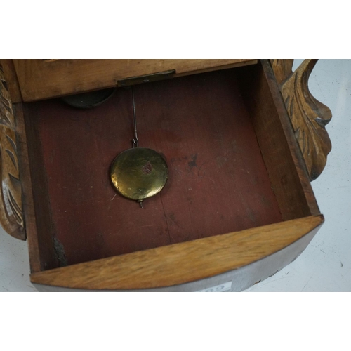 189 - A vintage wooden cased wall clock, white enamel dial with Roman numeral markers.