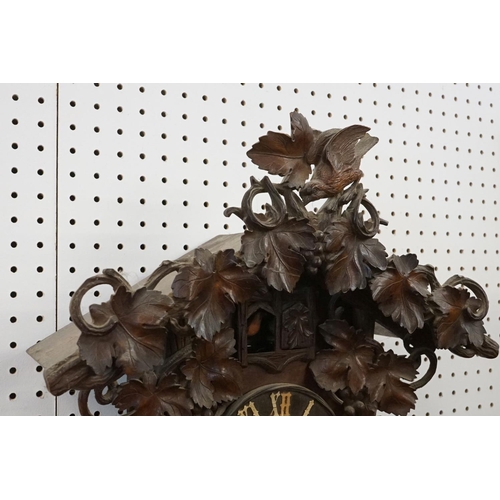 40 - Early 20th Century carved black forest cuckoo clock having carved wooden birds and vine leaves to th... 