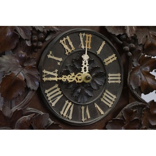 40 - Early 20th Century carved black forest cuckoo clock having carved wooden birds and vine leaves to th... 