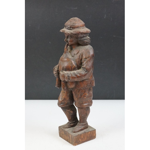 9 - Carved oak black forest style figure depicting a piper, together with a 1930's carved wooden novelty... 
