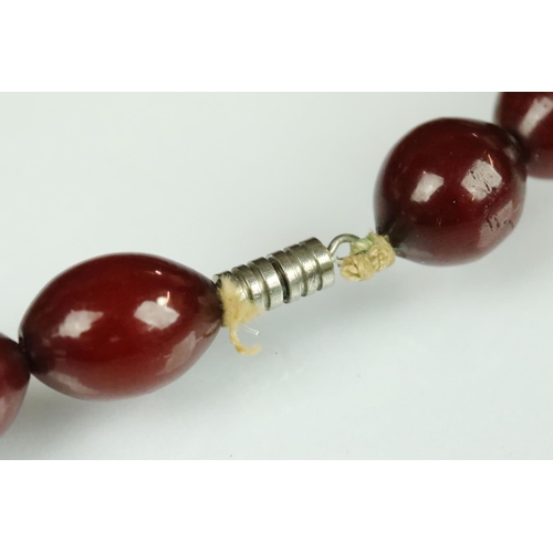 26 - Early 20th century cherry amber Bakelite bead necklace, forty-five graduated oval beads the largest ... 