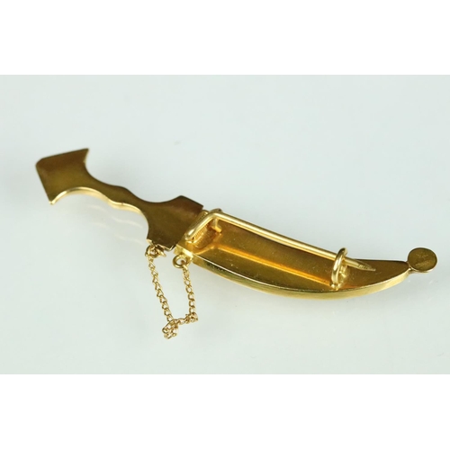 36 - Yellow metal brooch modelled as a sabre with filigree scabbard, hinged pin and simple loop brooch fi... 