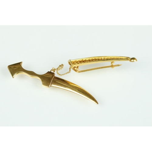 36 - Yellow metal brooch modelled as a sabre with filigree scabbard, hinged pin and simple loop brooch fi... 