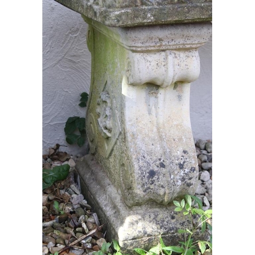 273 - Reconstituted stone garden bench / seat of rectangular form, raised on two feet scrolled feet. (Meas... 