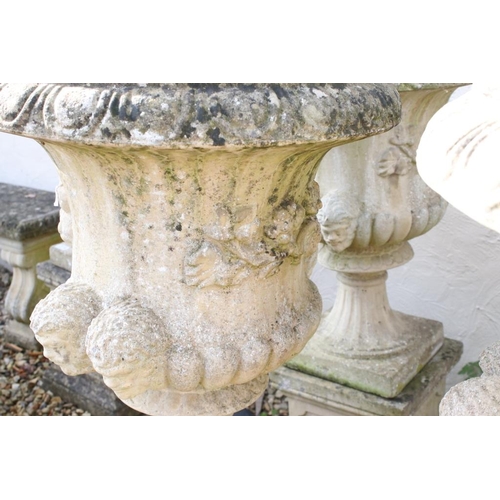 275 - Pair of reconstituted stone garden urns of campana form, with relief facial mask decoration and gadr... 