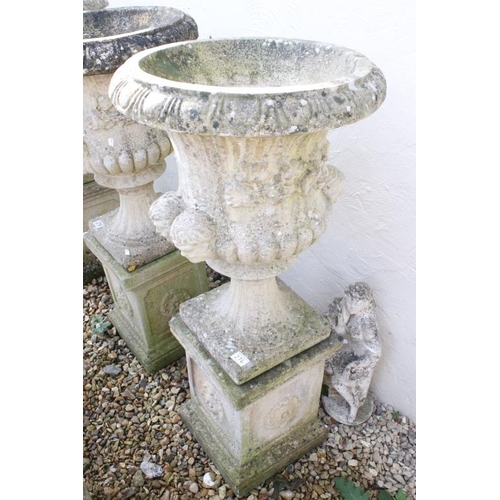 276 - Pair of reconstituted stone garden urns of campana form, with relief facial mask decoration and gadr... 