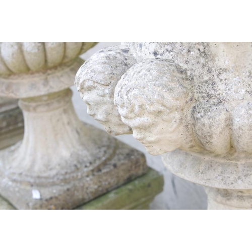 276 - Pair of reconstituted stone garden urns of campana form, with relief facial mask decoration and gadr... 