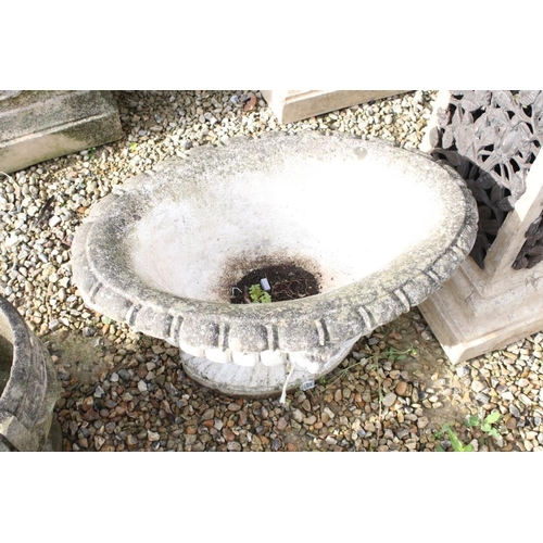 282 - Reconstituted stone garden planter of oval form, with relief lion masks, raised on a fluted oval foo... 