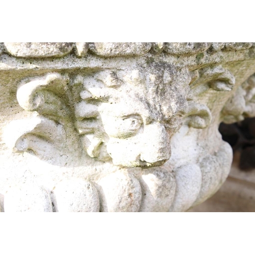 282 - Reconstituted stone garden planter of oval form, with relief lion masks, raised on a fluted oval foo... 