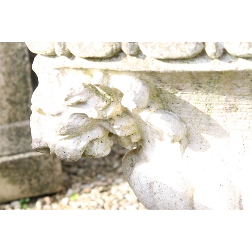 282 - Reconstituted stone garden planter of oval form, with relief lion masks, raised on a fluted oval foo... 