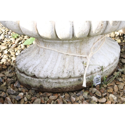 282 - Reconstituted stone garden planter of oval form, with relief lion masks, raised on a fluted oval foo... 