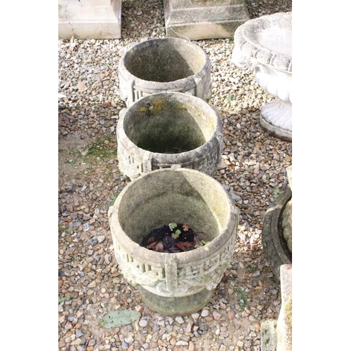 285 - Set of three reconstituted stone planters with Greek key and grape decoration, raised on circular fe... 